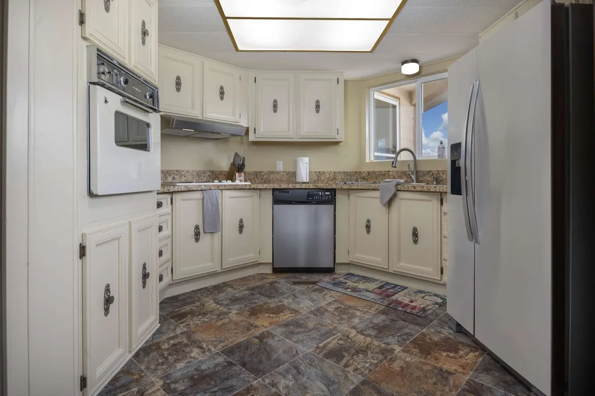 A spacious and inviting kitchen centered around a large island, with modern appliances and ample countertop space. The setting is styled for both cooking and gathering, conveying a sense of warmth and creativity. The kitchen’s unique layout is visible, with thoughtful organization for culinary activity and casual family meals.
